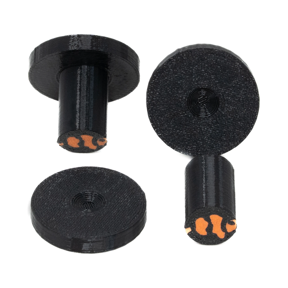 Round black frag plugs shown from above with their detachable stems