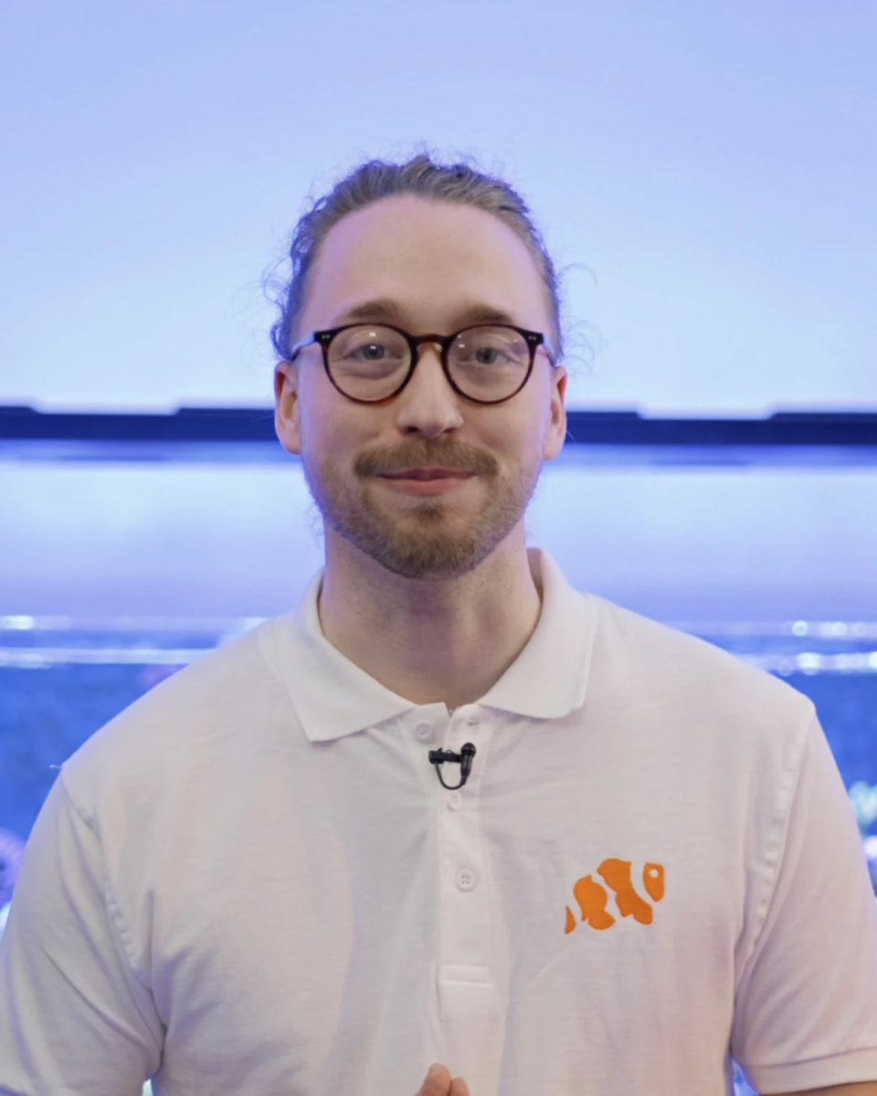 Harry of Marine Spec, smiling, wearing glasses and a white polo shirt with the orange Marine Spec fish logo