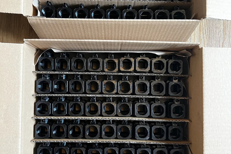 Cardboard boxes packed with rows of black custom matten filters ready to ship