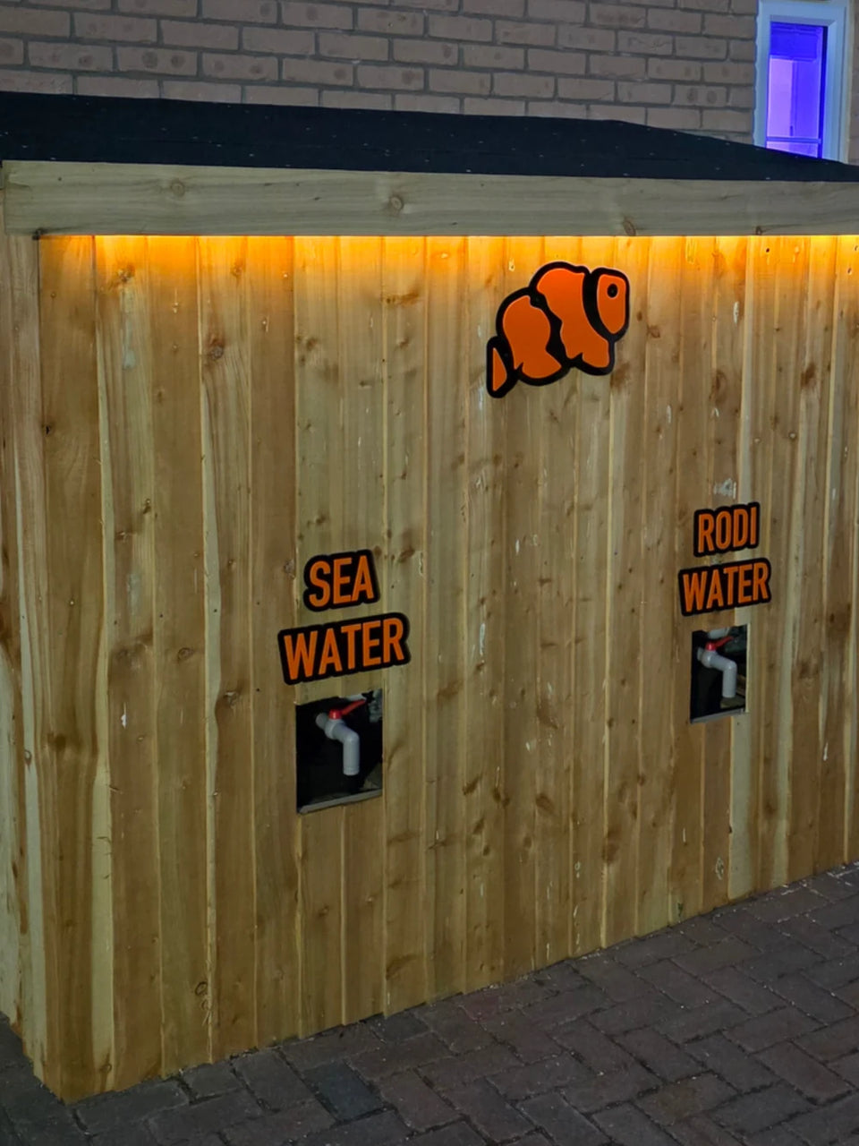 Marine Spec water dispensing hut with a wooden front and an orange LED strip