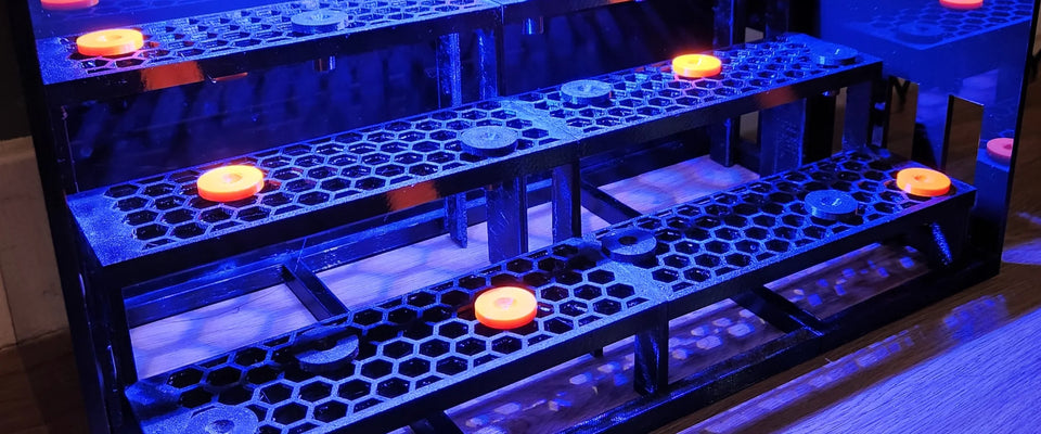 Standing frag racks in 5 colours on a dark lit stage