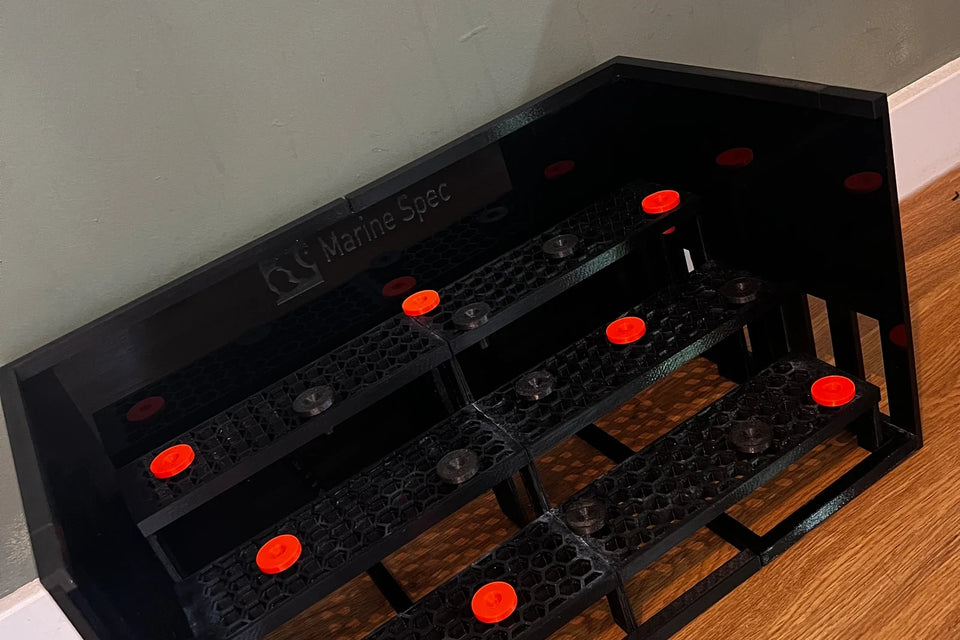 Black 3 tier sump frag rack with a black acrylic surround and red plugs on a wooden floor